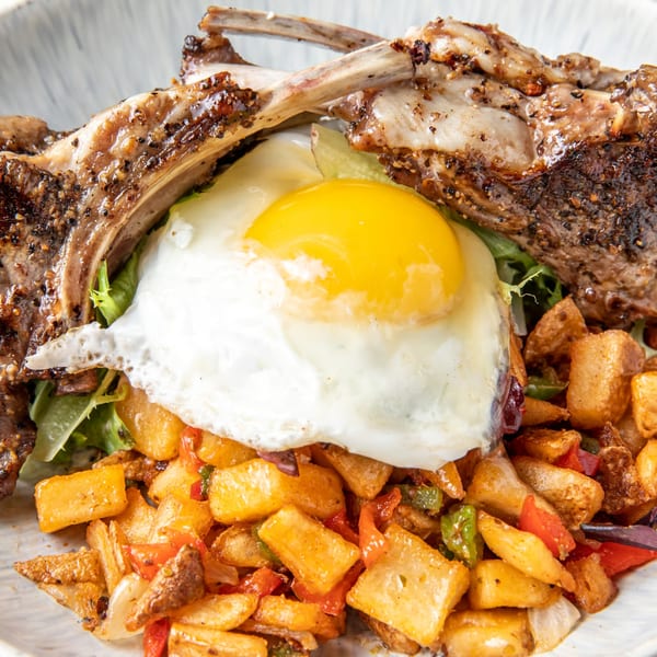 Just Brunch's lamb chops with a sunny-side-up egg, home fries, and mixed greens.